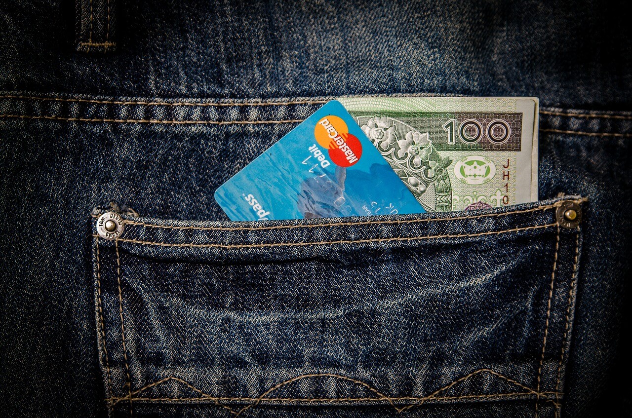 karta kredytowa i banknot 100-złotowy w kieszeni